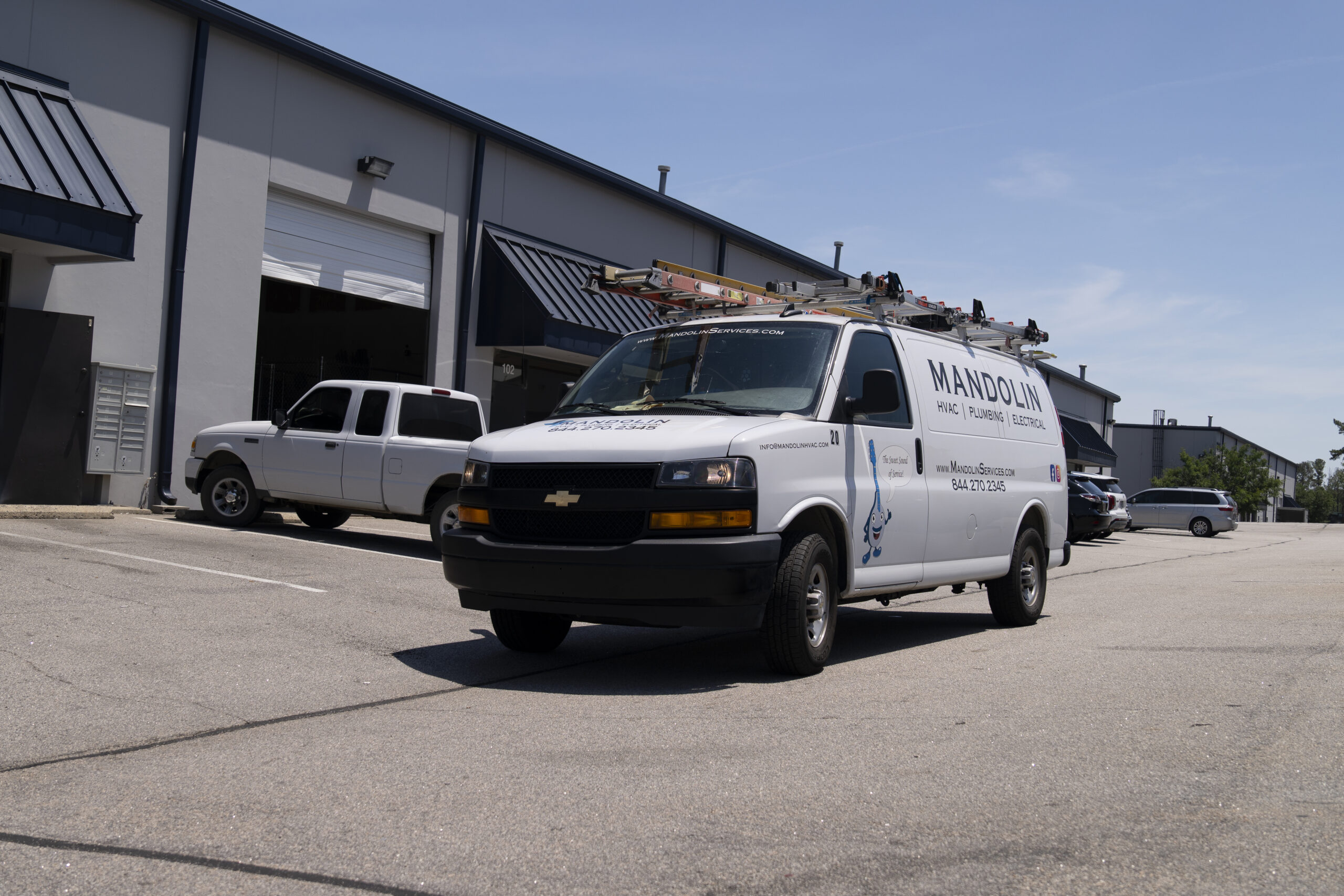 Mandolin Services technician inspecting residential cooling equipment during an AC maintenance visit